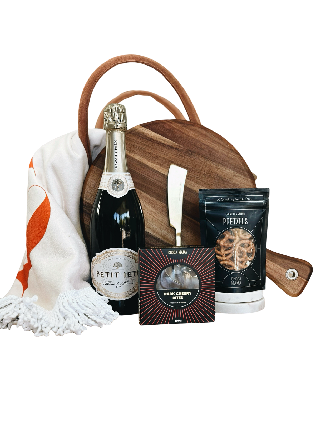 Gift basket with champagne, snacks, and a wooden board on a white background