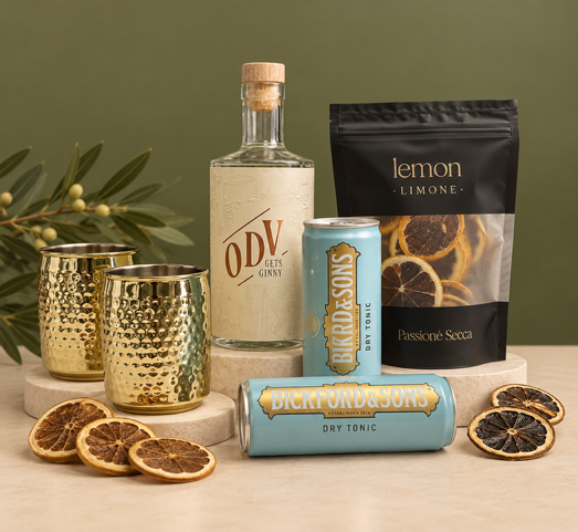 ODV gin bottle with tonic water, lemon slices, and decorative glasses on a white background