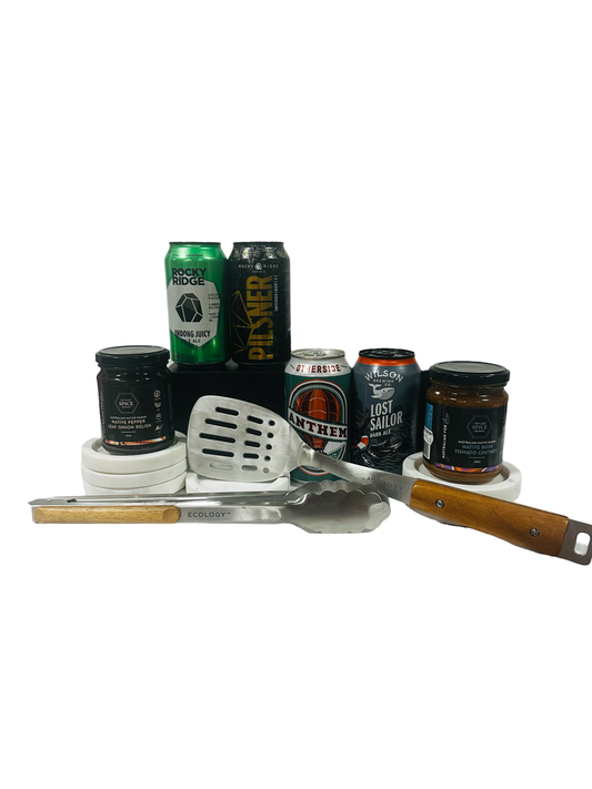 A gift set including various craft beers, Ecology BBQ tools, and gourmet delights from Infuse Spice Company presented in a matte black gift box.