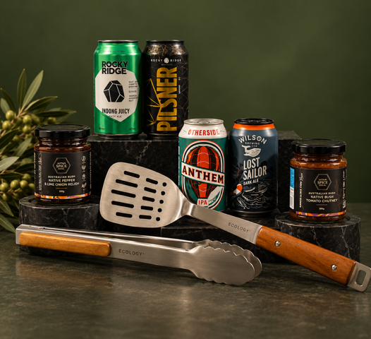 Selection of beers, jars of chutney  and BBQ tools on green background