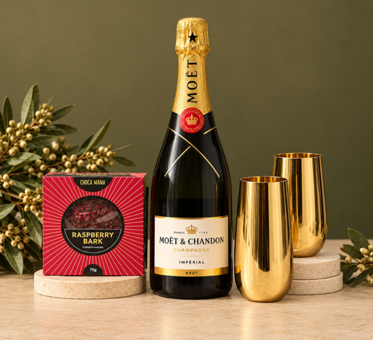 Bottle of Moet & Chandon champagne with two gold flutes and a box on a beige background