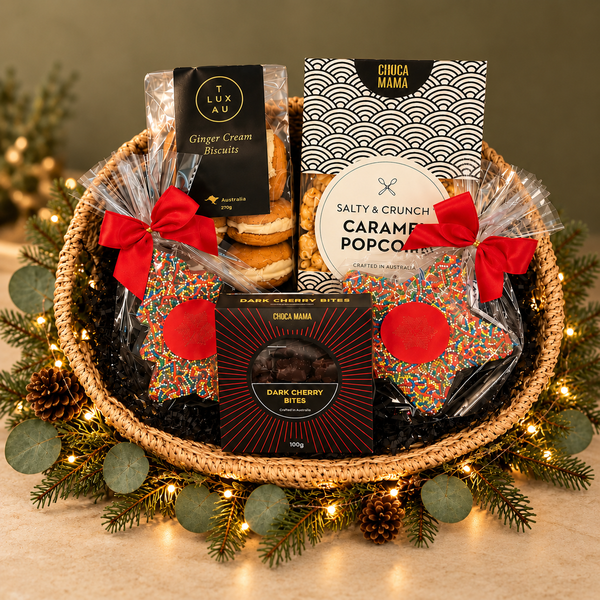 Small basket with popcorn, chocolates and Christmas sprinkle star and Christmas tree. On green background with greenery and lights