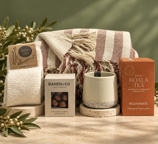 Striped blanket, comfortable socks, ceramic tumbler, tea and gourmet treats on green background with greenery