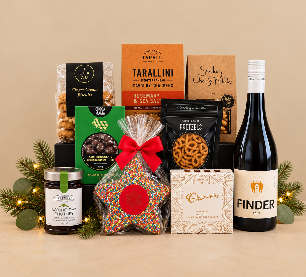 Selection of gourmet and bottle of wine on beige background with greenery.