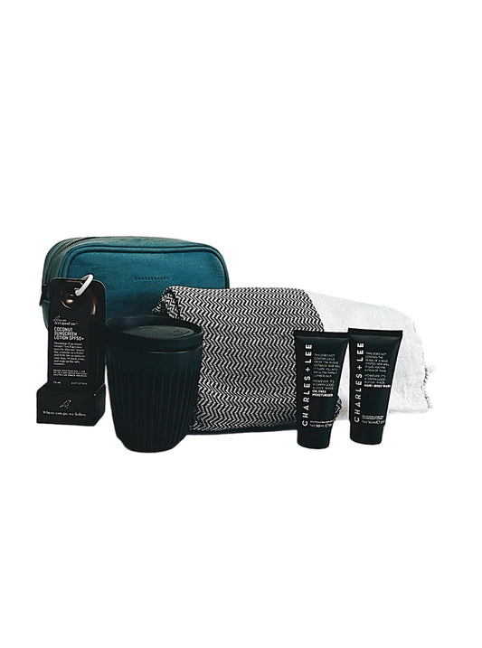 A gift set including a toiletry bag, mini products, a Turkish towel, a reusable coffee cup, and a mini sunscreen, all presented in a magnetic gift box.