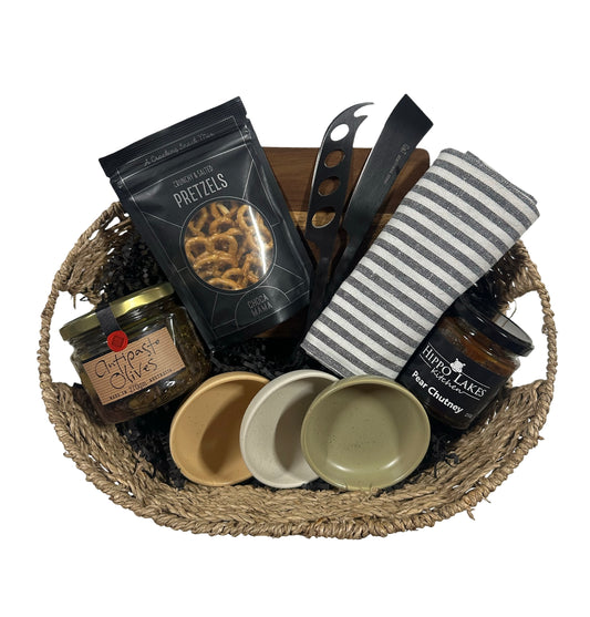Gift basket with pretzels, jars, and a blanket on a white background