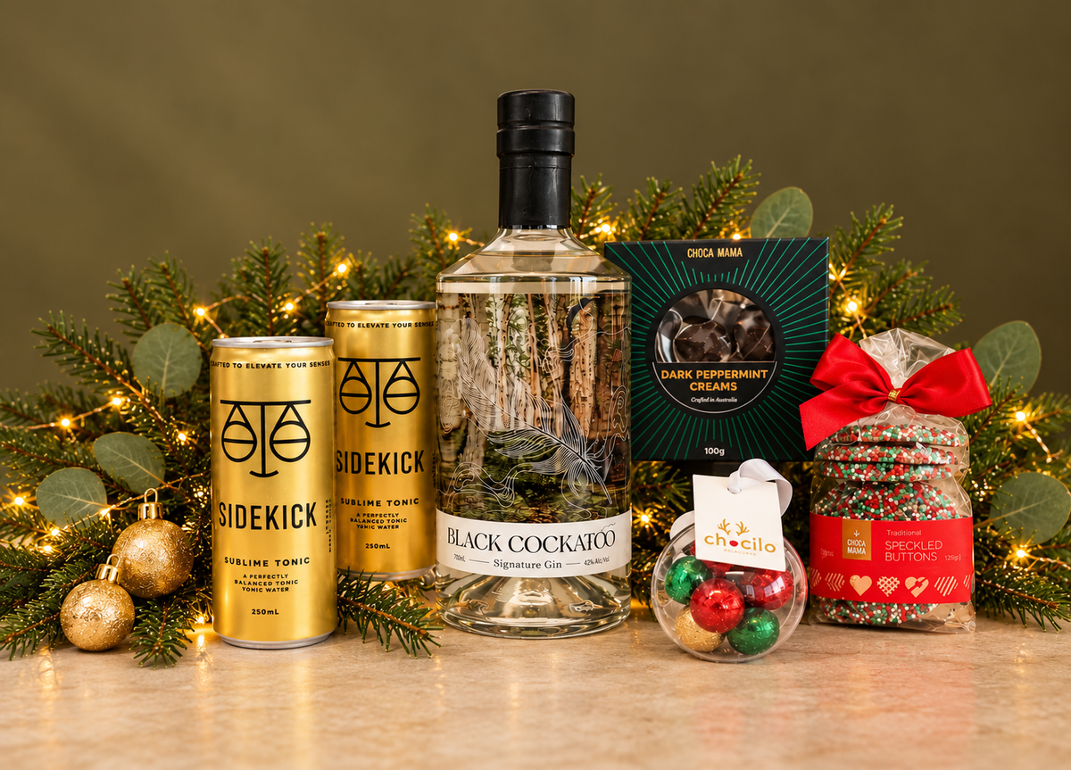 A stylish Christmas gift for those who appreciate quality gin, great taste and a little indulgence. Featuring Black Cockatoo Signature Gin, premium Sidekick tonics, Choca Mama dark peppermint creams and festive sweet treats.
Presented in a sophisticated black gift box and finished with luxurious ribbon, this gift brings together premium Australian spirits, artisan treats and festive flair — a fun yet refined choice for clients, colleagues or special celebrations.
