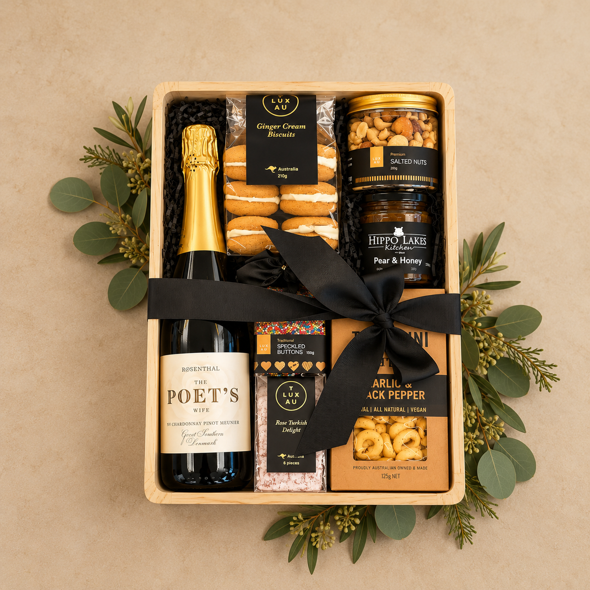 A beautifully curated Christmas gift filled with premium gourmet favourites and indulgent treats. Featuring The Poet’s Wife Chardonnay Pinot Meunier, artisan ginger cream biscuits, premium salted nuts, pear & honey preserve, rose Turkish delight, colourful speckled chocolate buttons and savoury garlic & black pepper tarallini.
Presented in a stylish timber gift box with a luxurious black satin bow, this generous collection is perfect for sharing and celebrating over the festive season. 