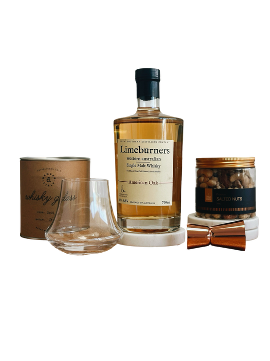 Limeburners whisky bottle with glass, canisters, and a box on a white background