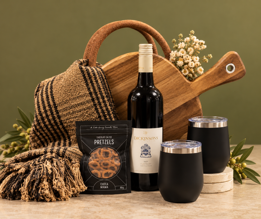 Picnic basket  with wine bottle, paddle board, glasses, and blanket on a green background
