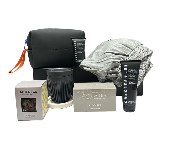 Collection of items including a black pouch, gray towel, tea packaging, and skincare product on a white background.