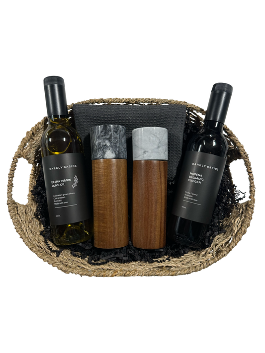 Wine bottles and wooden items in a woven basket on a white background