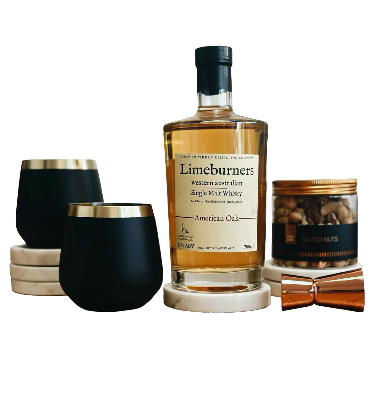 Limeburners single malt whisky bottle with black tumblers and a small container on a white background