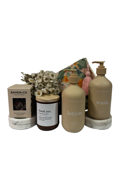 Nude colour body wash and lotion. candle and square box of chocolates