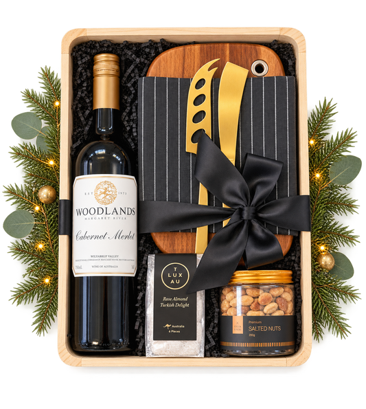 A sophisticated gift celebrating great wine, beautiful design and relaxed entertaining. Featuring a Woodlands Margaret River Cabernet Merlot, a beautiful timber serving board, elegant gold cheese tools, a premium linen tea towel, artisan rose almond Turkish delight and gourmet salted nuts.
Presented in a natural timber gift box and finished with a luxurious black satin bow, this is a stylish and generous Christmas gift.