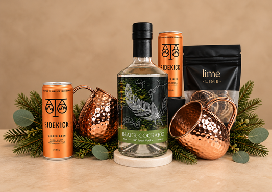 A stylish gift designed for relaxed entertaining and festive celebrations. Featuring premium Black Cockatoo Vodka, Sidekick Ginger Beer, zesty lime and two beautiful hammered copper Moscow Mule mugs — everything needed to create the perfect drink at home.
Presented in a sleek black gift box and finished with luxurious black ribbon and subtle festive touches, this is a fun, sophisticated Christmas gift with a distinctly Australian flavour.
