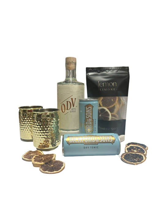 ODV gin bottle with tonic water, lemon slices, and decorative glasses on a white background