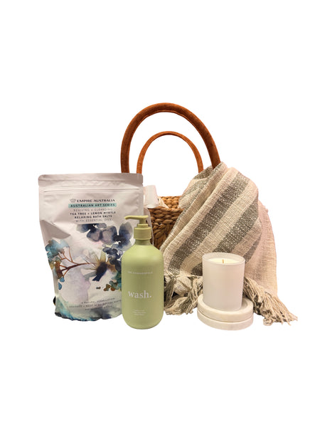 basket with blanket, pamper items and candles on a white background