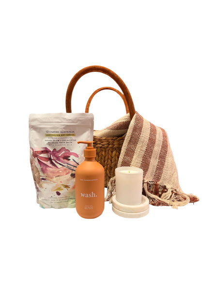 Basket with blankets, pamper products and candle.