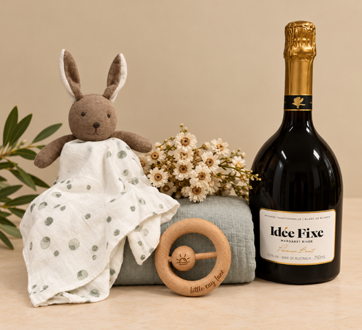Gift box containing bottle of sparkling, comforter, swaddle and teether.